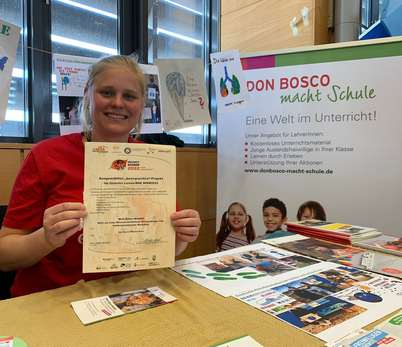 Referentin hält Auszeichnung hoch