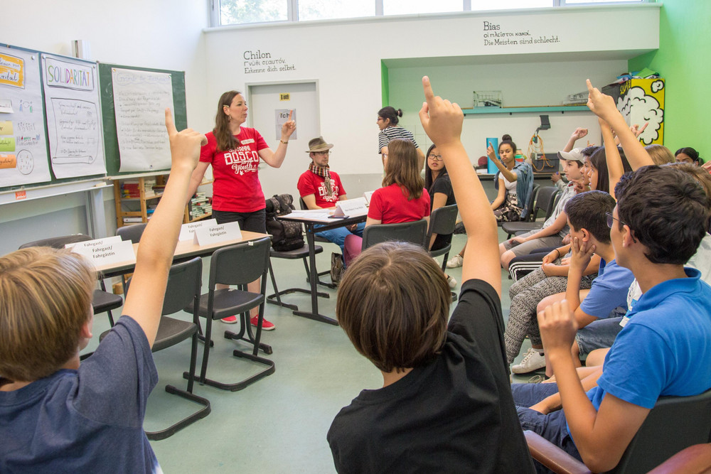 mehrere Schüler zeigen auf