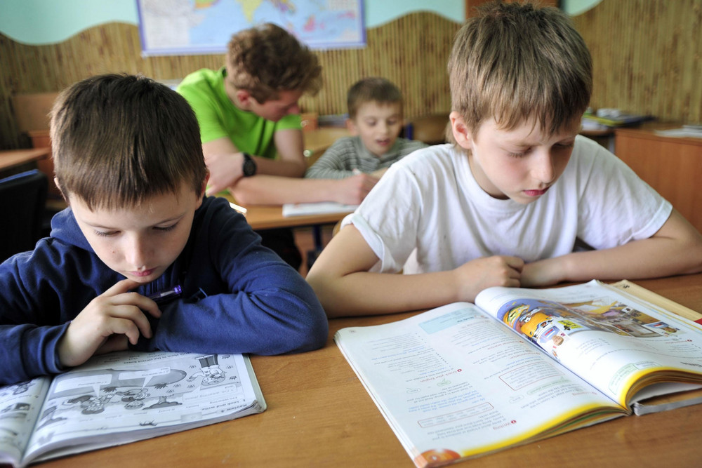 Schüler lesen in Unterrichtsmaterial