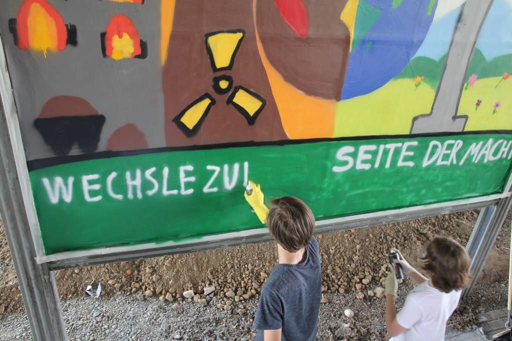 Schüler*innen gestalten eine Plakatwand mit Botschaften zum Klima