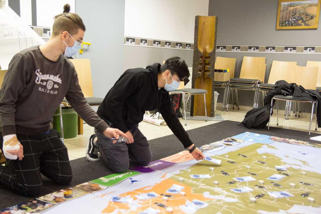 Schüler lehnen sich über Weltkarte